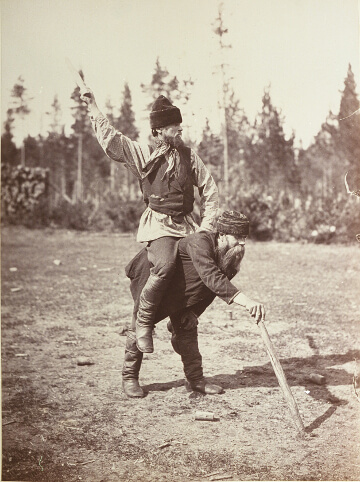 Ein Kyykkä-Sieger reitet auf dem Rücken eines geschlagenen Gegners.